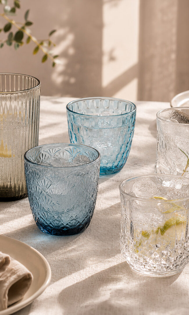 Vasos de cristal originales de colores y relieves distintos combinados en la misma mesa: Bidasoa, Luminarc y Bormioli Rocco