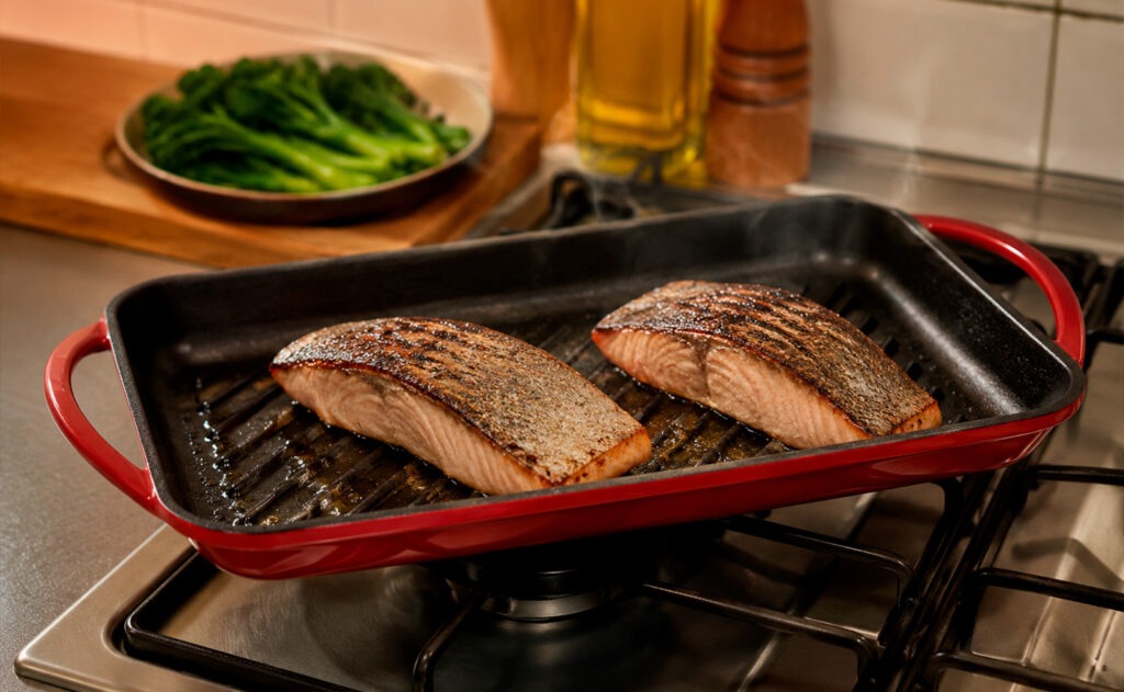 Verduras, carne y pescado cocinados en grill asador de acero inoxidable con marcas de parrilla