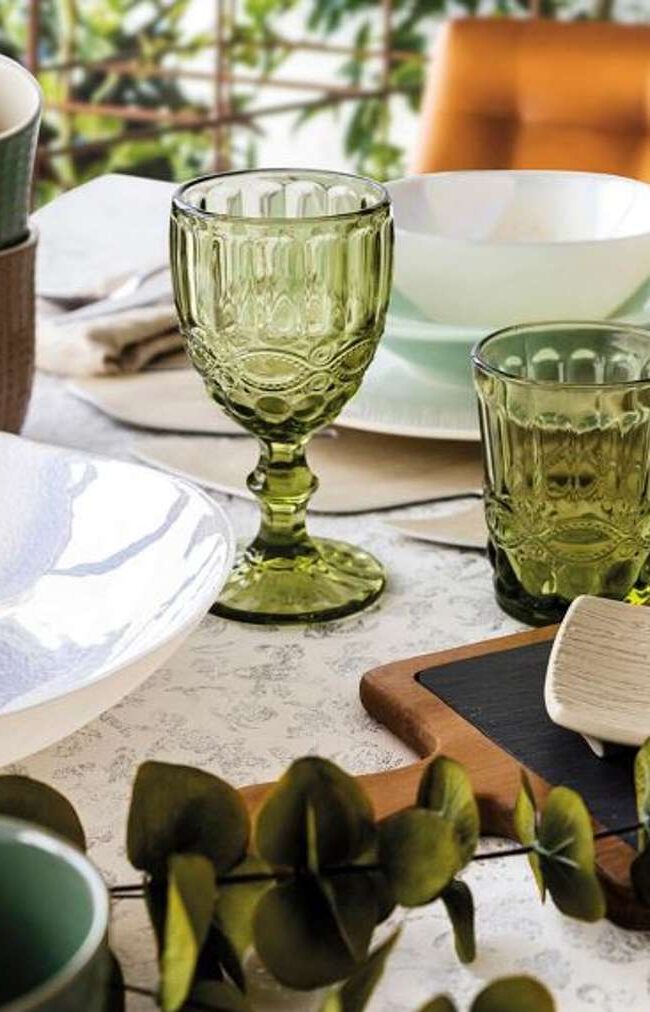 Una mesa impecablemente dispuesta con vajilla y copas elegantes.