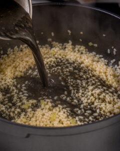 Arroz meloso de choco con mayonesa de tinta negra servido en plato hondo blanco