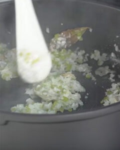 Arroz meloso de choco con mayonesa de tinta negra servido en plato hondo blanco