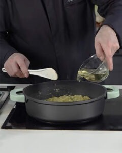 Arroz meloso de choco con mayonesa de tinta negra servido en plato hondo blanco