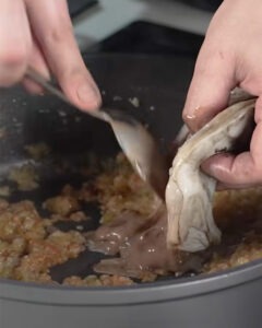 Arroz meloso de choco con mayonesa de tinta negra servido en plato hondo blanco