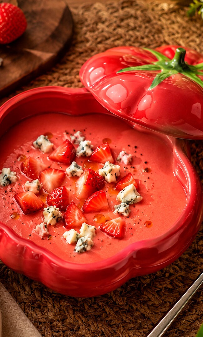 Gazpacho de fresas con queso azul servido en bol hondo con daditos de fresa y sal negra