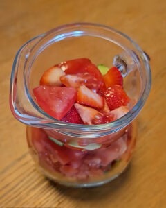 Gazpacho de fresas con queso azul servido en bol hondo con daditos de fresa y sal negra