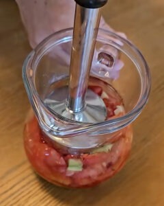 Gazpacho de fresas con queso azul servido en bol hondo con daditos de fresa y sal negra