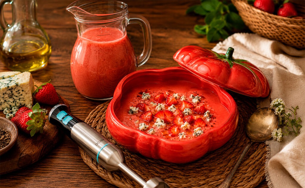 Gazpacho de fresas con queso azul servido en bol hondo con daditos de fresa y sal negra