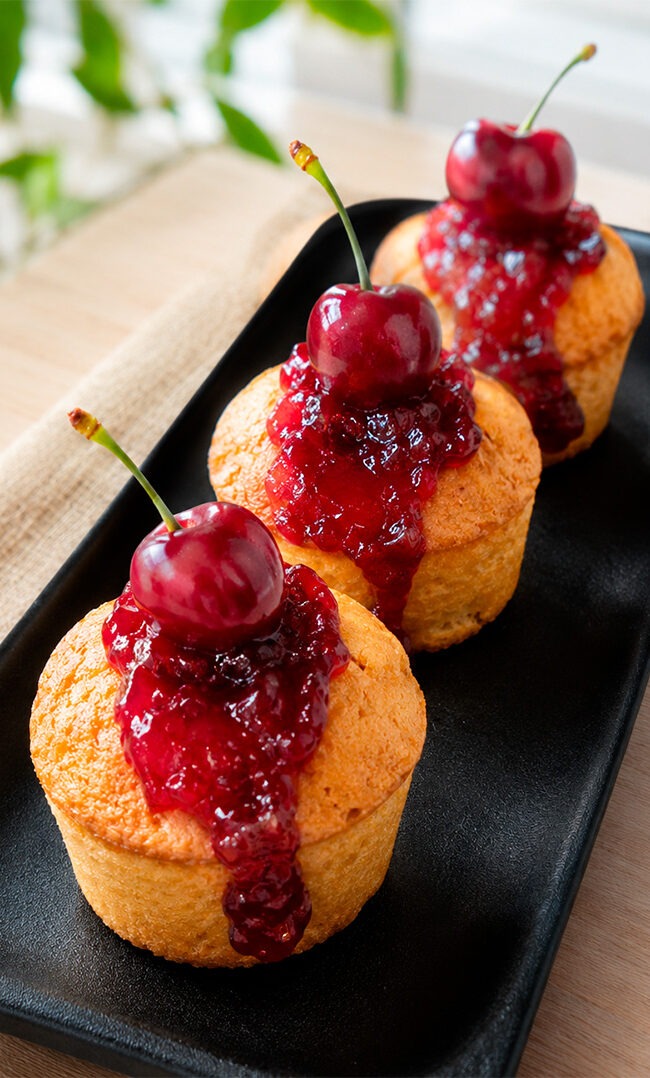 Muffins de cereza en airfryer esponjosos con mermelada y cerezas frescas sobre bandeja negra