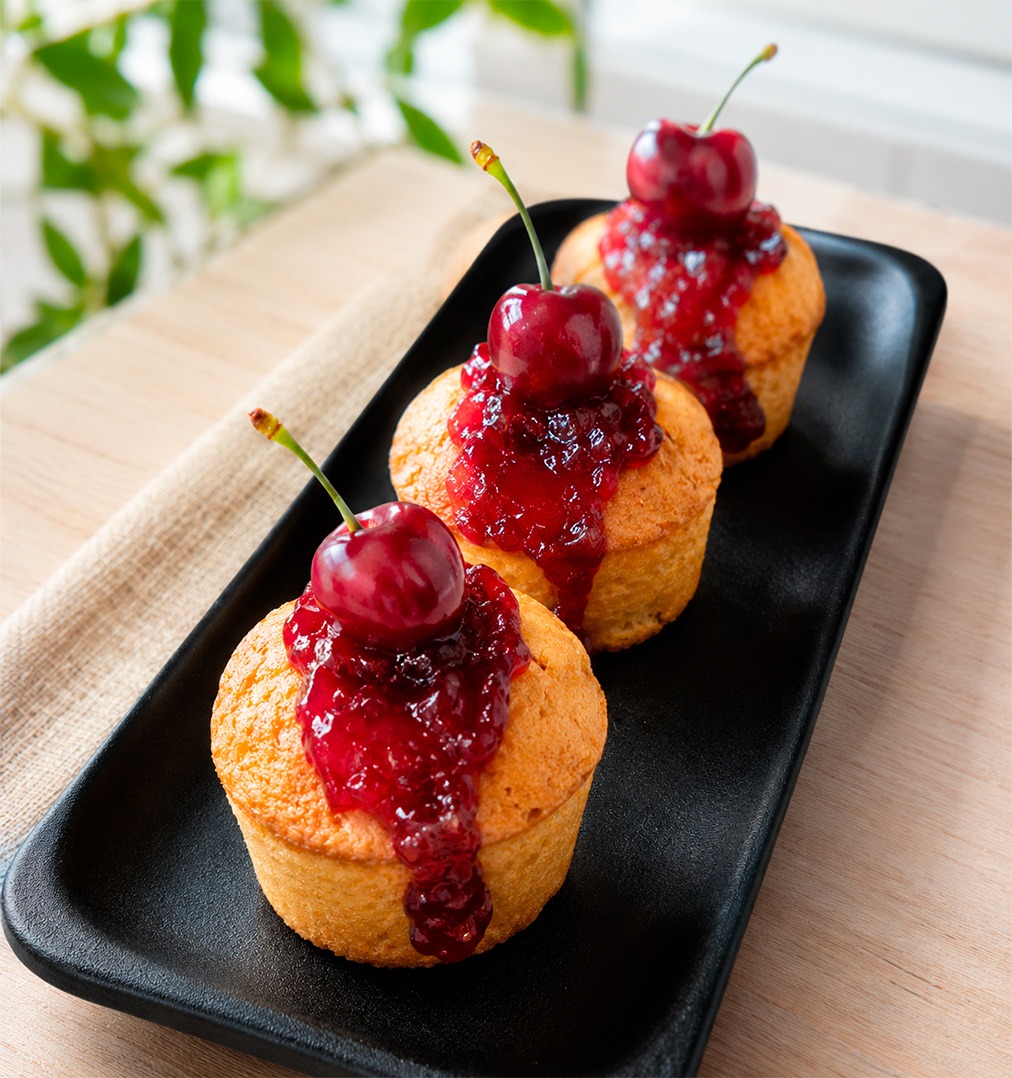 Muffins de cereza en airfryer esponjosos con mermelada y cerezas frescas sobre bandeja negra