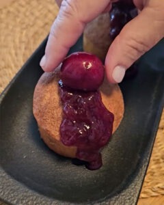 Muffins de cereza en airfryer esponjosos con mermelada y cerezas frescas sobre bandeja negra