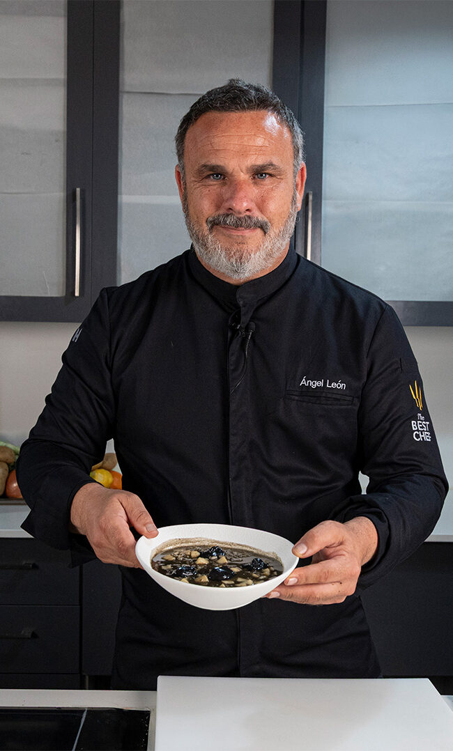 Arroz meloso de choco con mayonesa de tinta negra servido en plato hondo blanco