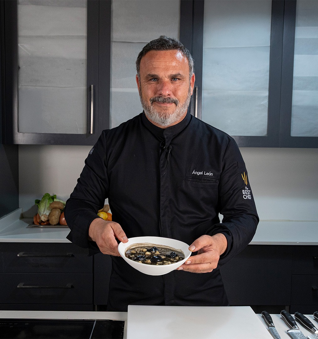 Arroz meloso de choco con mayonesa de tinta negra servido en plato hondo blanco