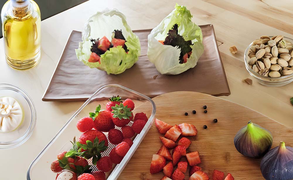 Ensalada fresca en bol de iceberg con frutas, burrata y pistachos