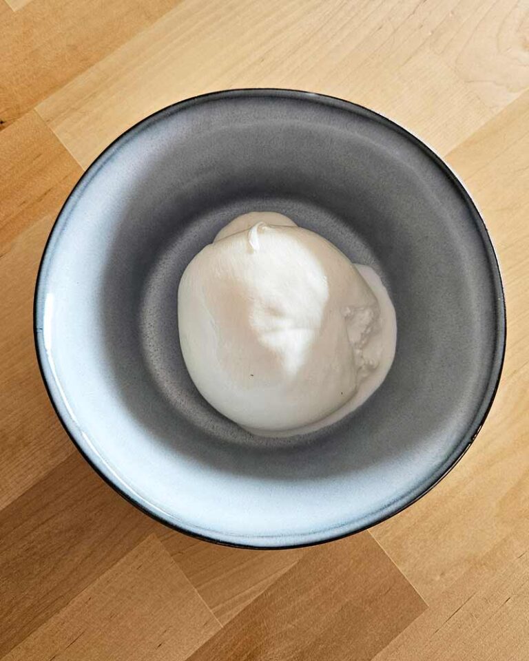 Ensalada fresca en bol de iceberg con frutas, burrata y pistachos