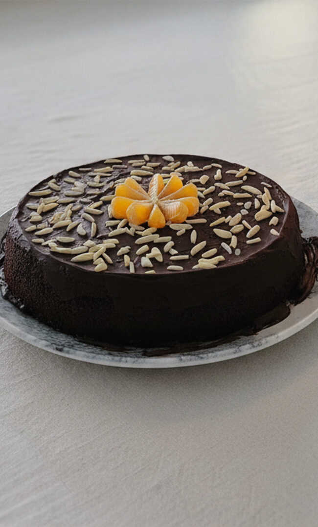 Tarta de mandarina, chocolate negro y almendras decorada con frutas y frutos secos