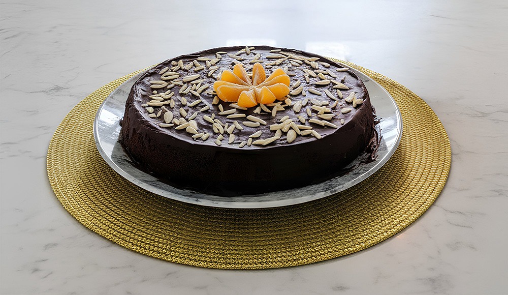 Tarta de mandarina, chocolate negro y almendras decorada con frutas y frutos secos